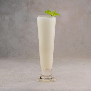 A chilled glass of lassi garnished with fresh mint leaves, perfect for a refreshing treat.