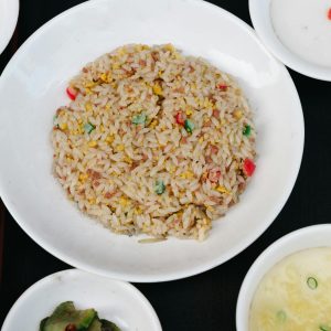 Tasty Asian fried rice served with multiple side dishes, captured in a classic flat lay.