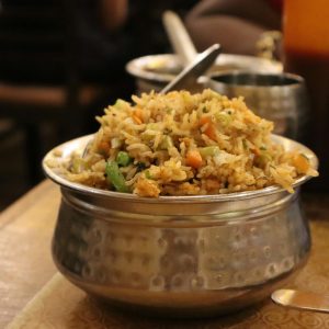 A flavorful serving of Indian fried rice with vegetables in a traditional metal bowl, ideal for food enthusiasts.