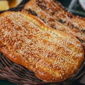 Delicious flatbreads topped with sesame and nigella seeds in a wicker basket.