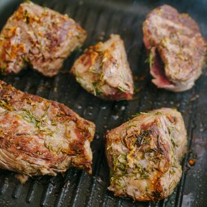 Deliciously seasoned lamb chops roasting with herbs in a grill pan.