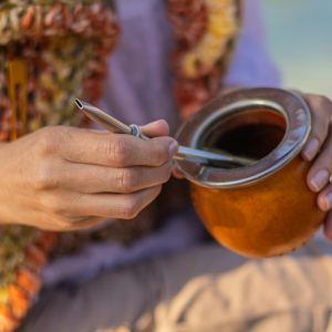 A person holding a traditional mate drink with a bombilla in Montevideo, Uruguay.