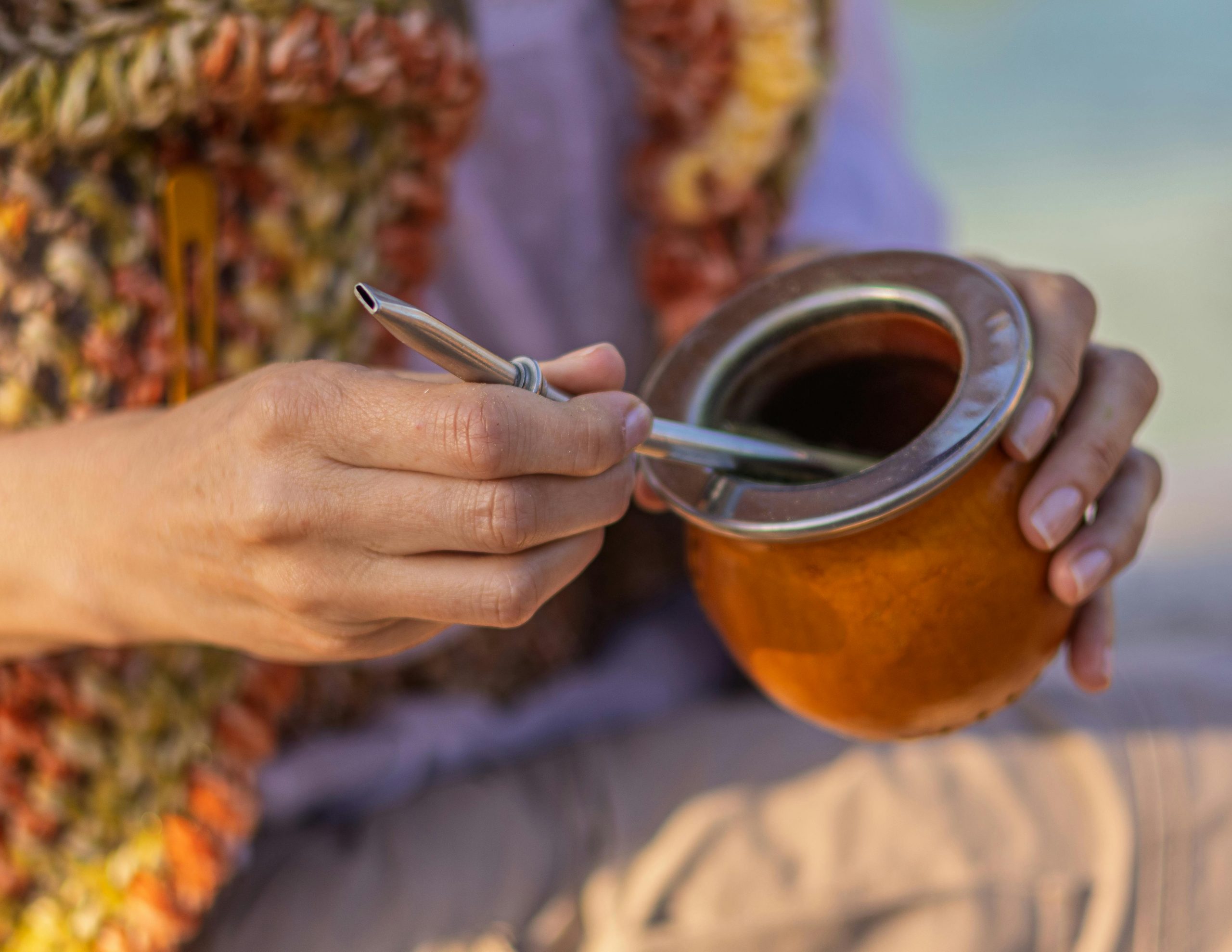 A person holding a traditional mate drink with a bombilla in Montevideo, Uruguay.