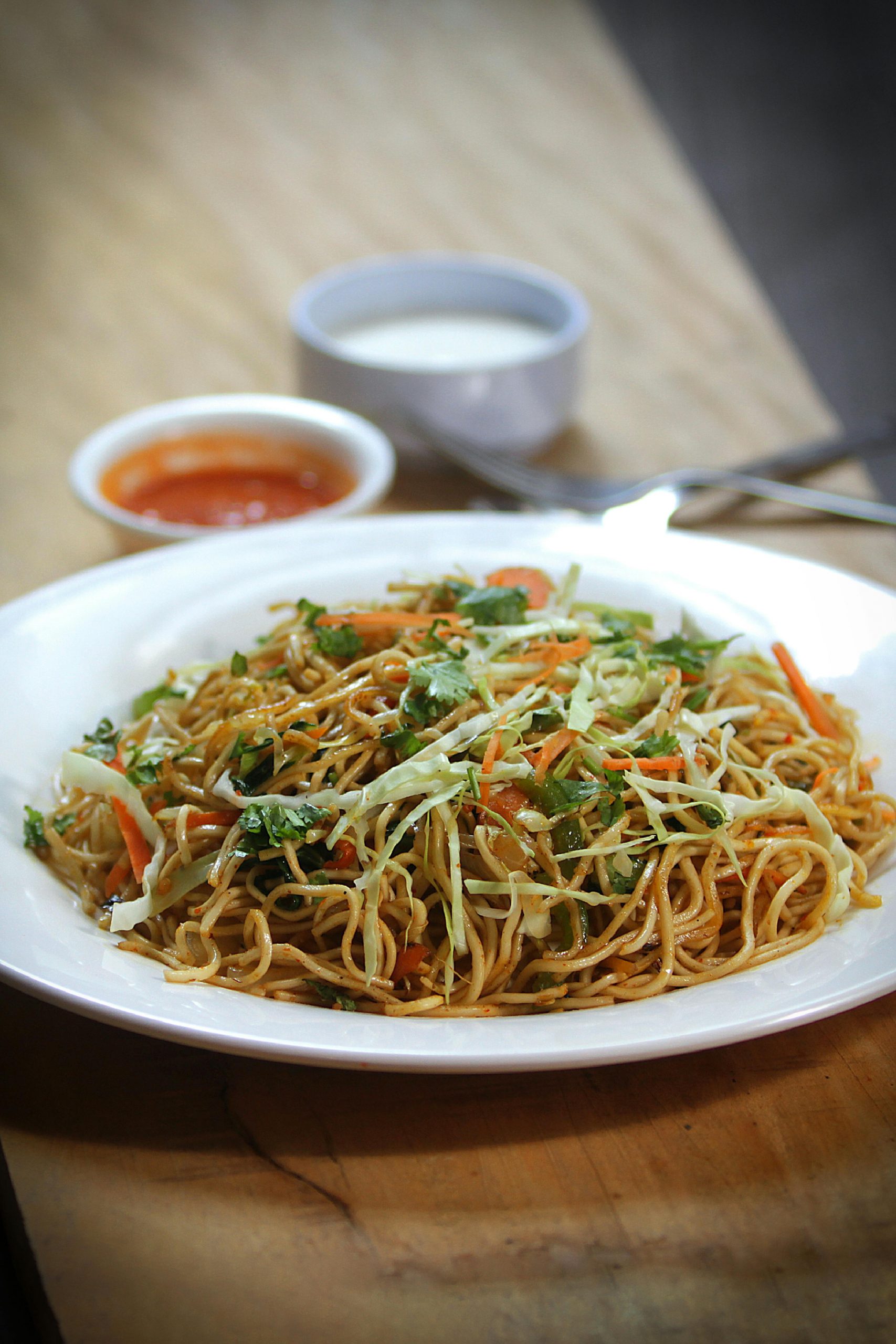 A tempting plate of vegetable chow mein with noodles and veggies on a table.