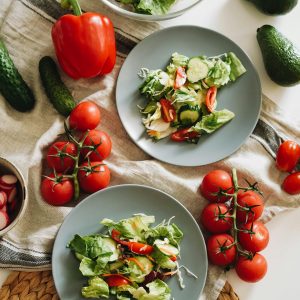 Top view of a vibrant vegetable salad featuring fresh ingredients on plates and a towel.