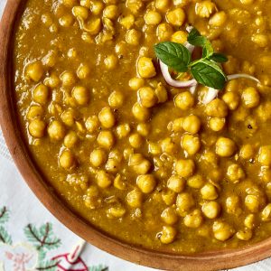 A close-up of traditional Indian chana masala garnished with fresh herbs, showcasing its rich and appetizing flavors.